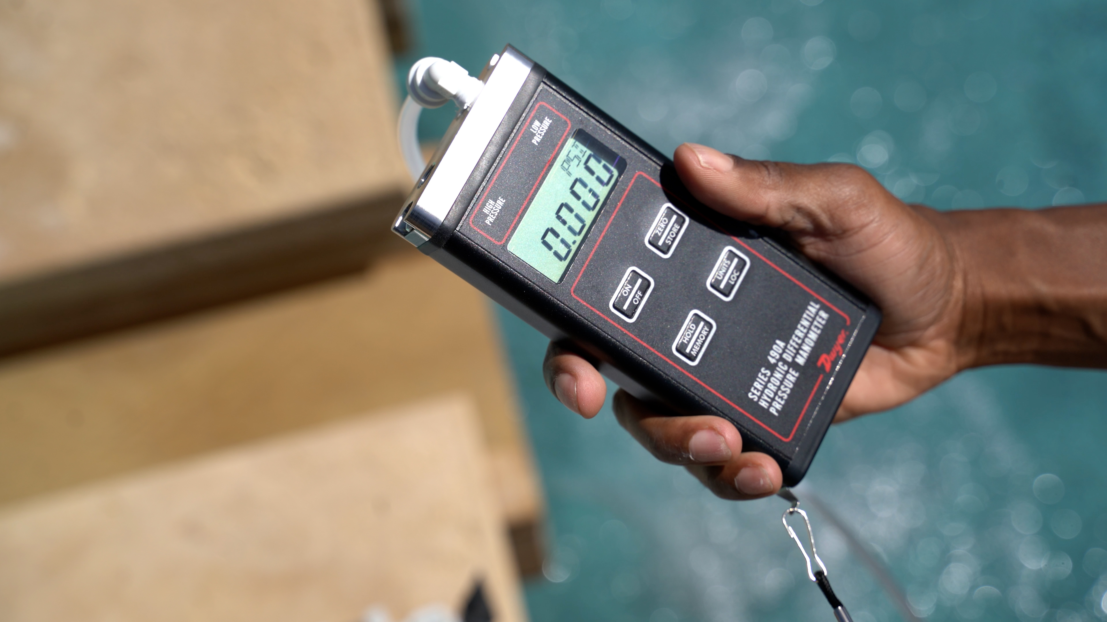 Dolphin Premier Hand Holding Pressure Meter Near Pool Edge