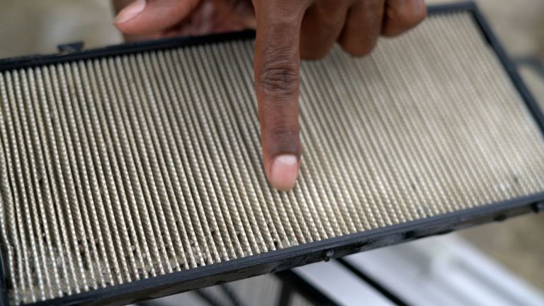 Dolphin Premier Finger Pointing Dirty Filter Cartridge Closeup