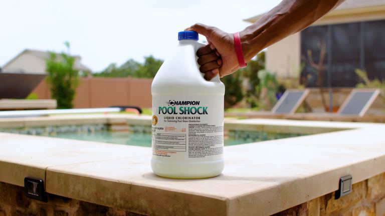 Champion Pool Shock Hand Gripping Jug On Ledge Second Angle