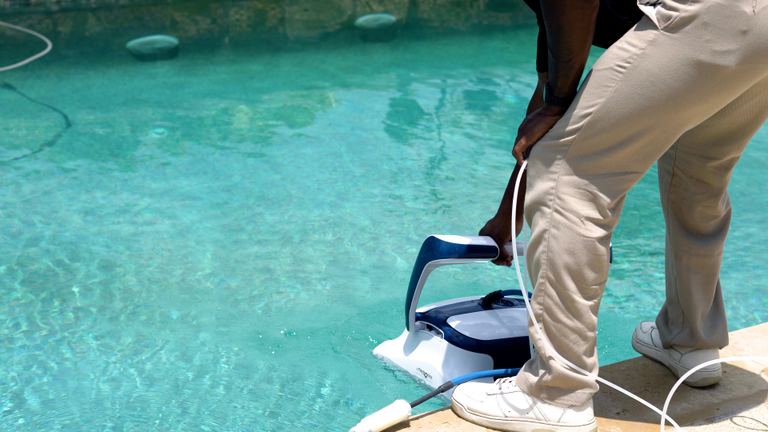 Dolphin Sigma Person Placing Robot Cleaner Into Pool