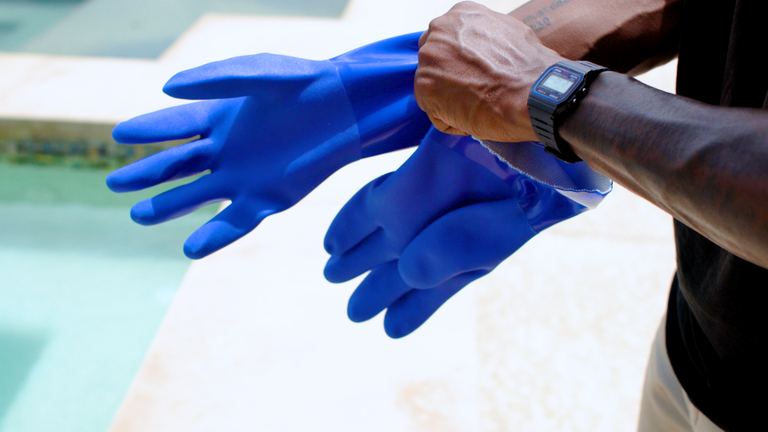 Wells Lamont PVC Gloves Pulling First Glove Onto Hand Poolside