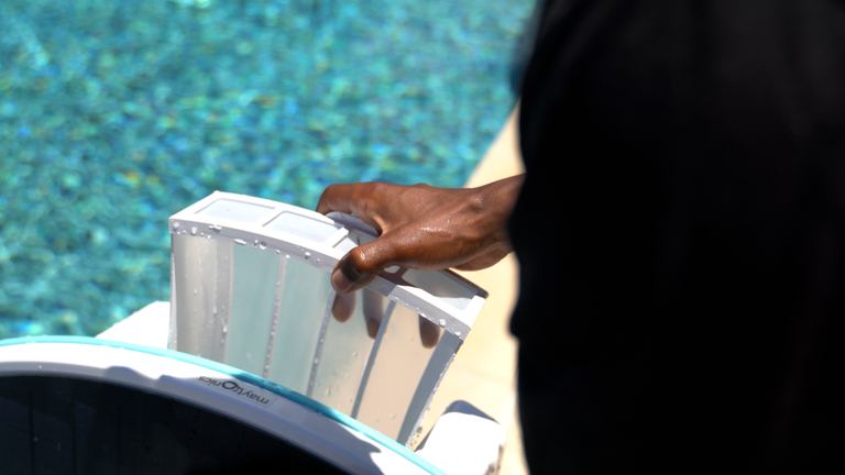 Dolphin Skimmi Hand Removing Filter From Robot Closeup